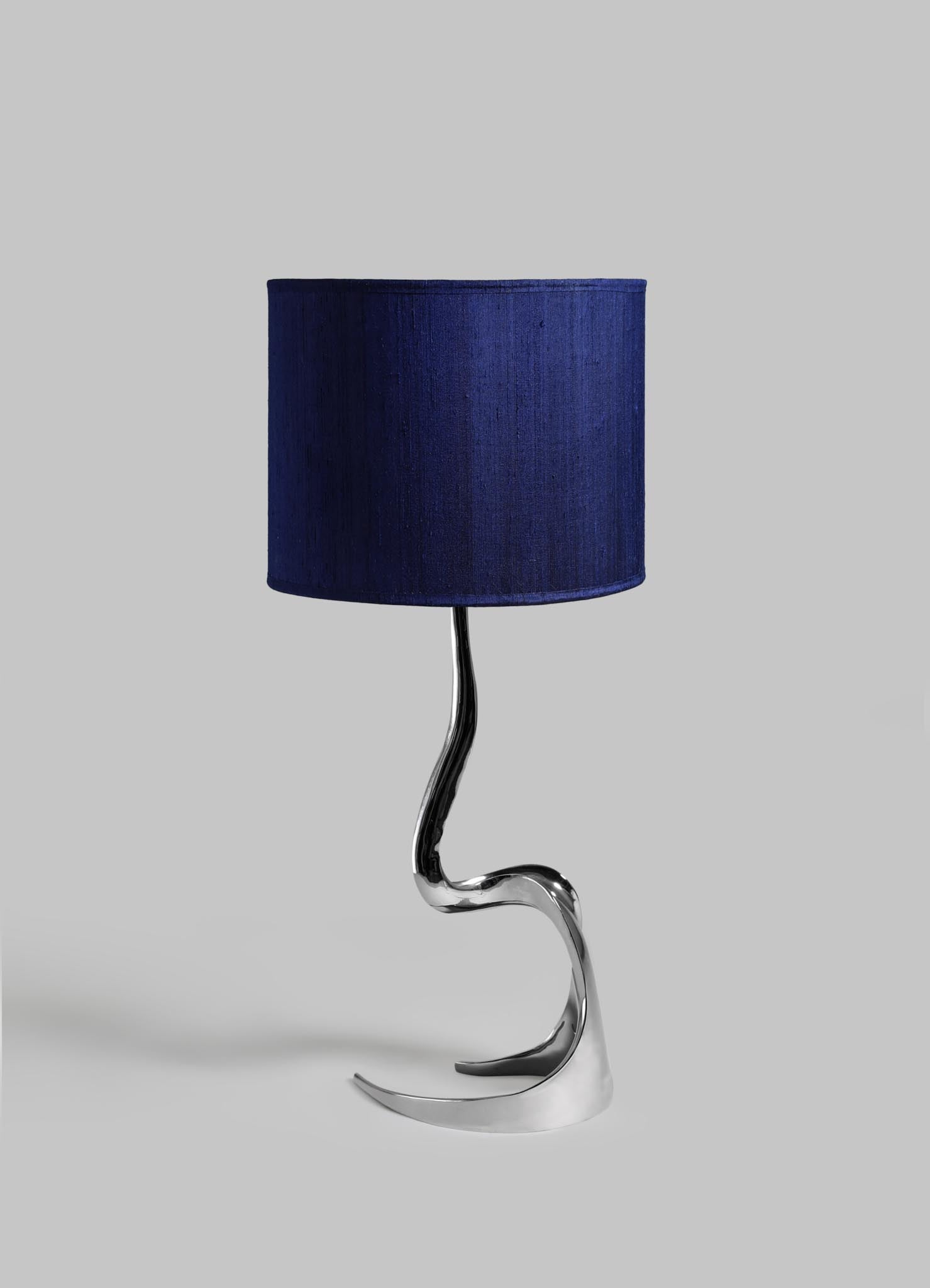 Table lamp with a blue shade and wavy metal base on a light gray background viya designer luxury table lamp