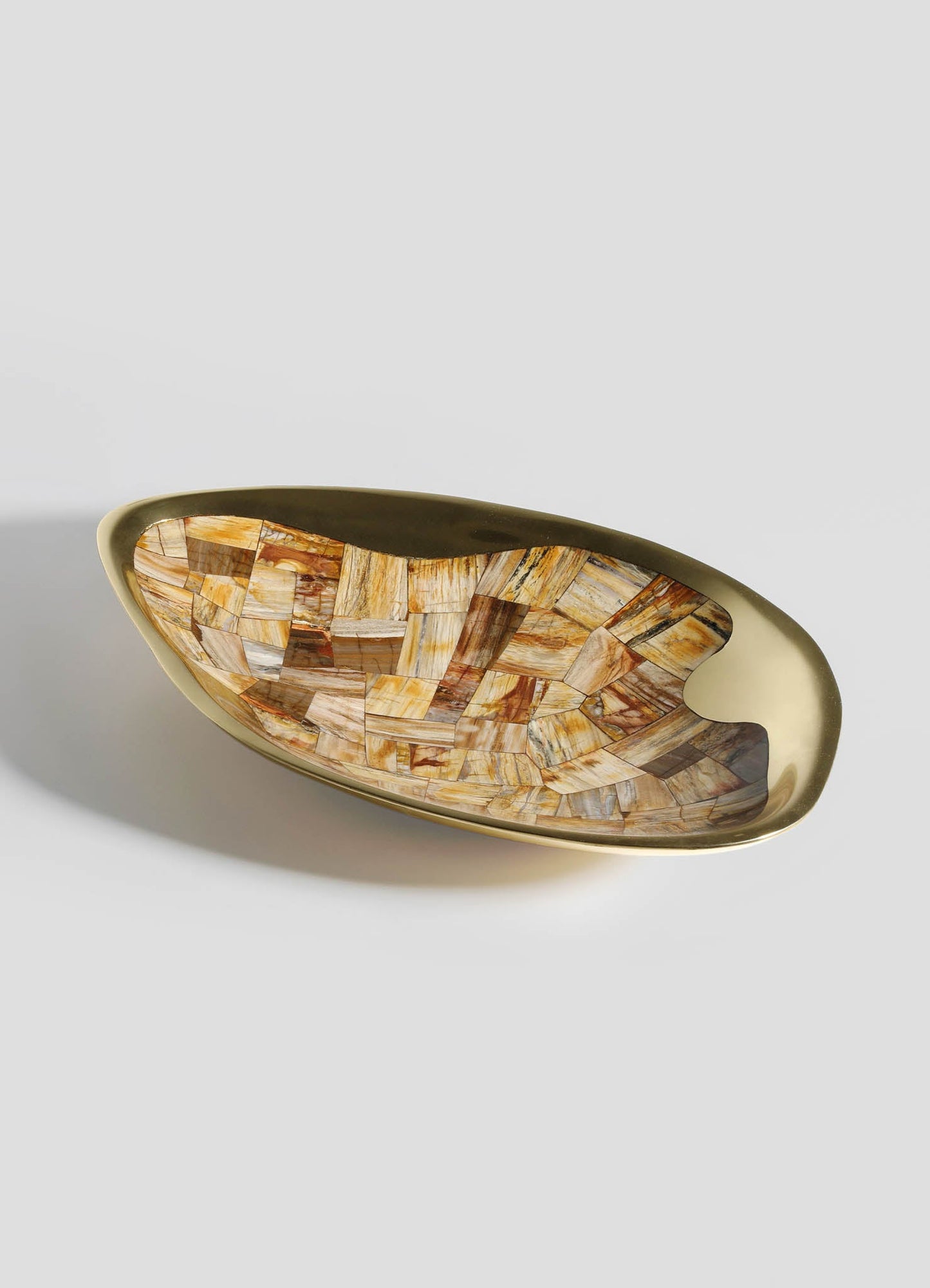 A decorative bowl with a smooth ceramic exterior in a muted beige tone, featuring an intricate mosaic pattern inside composed of small, irregularly shaped tiles in warm earthy shades of brown, orange, and cream.