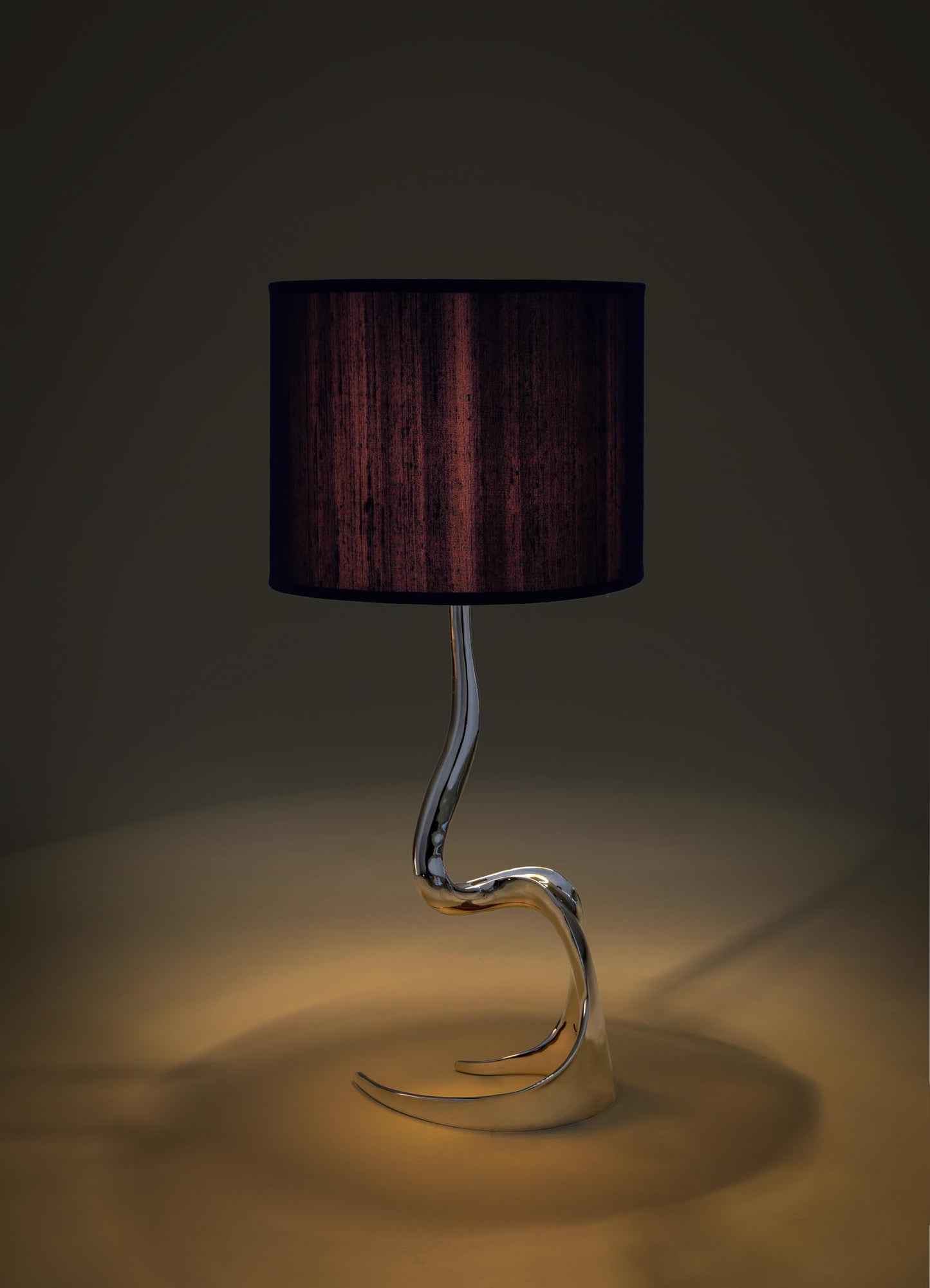 Modern table lamp with a black shade and curved glass base on a dark background viya designer luxury table lamp