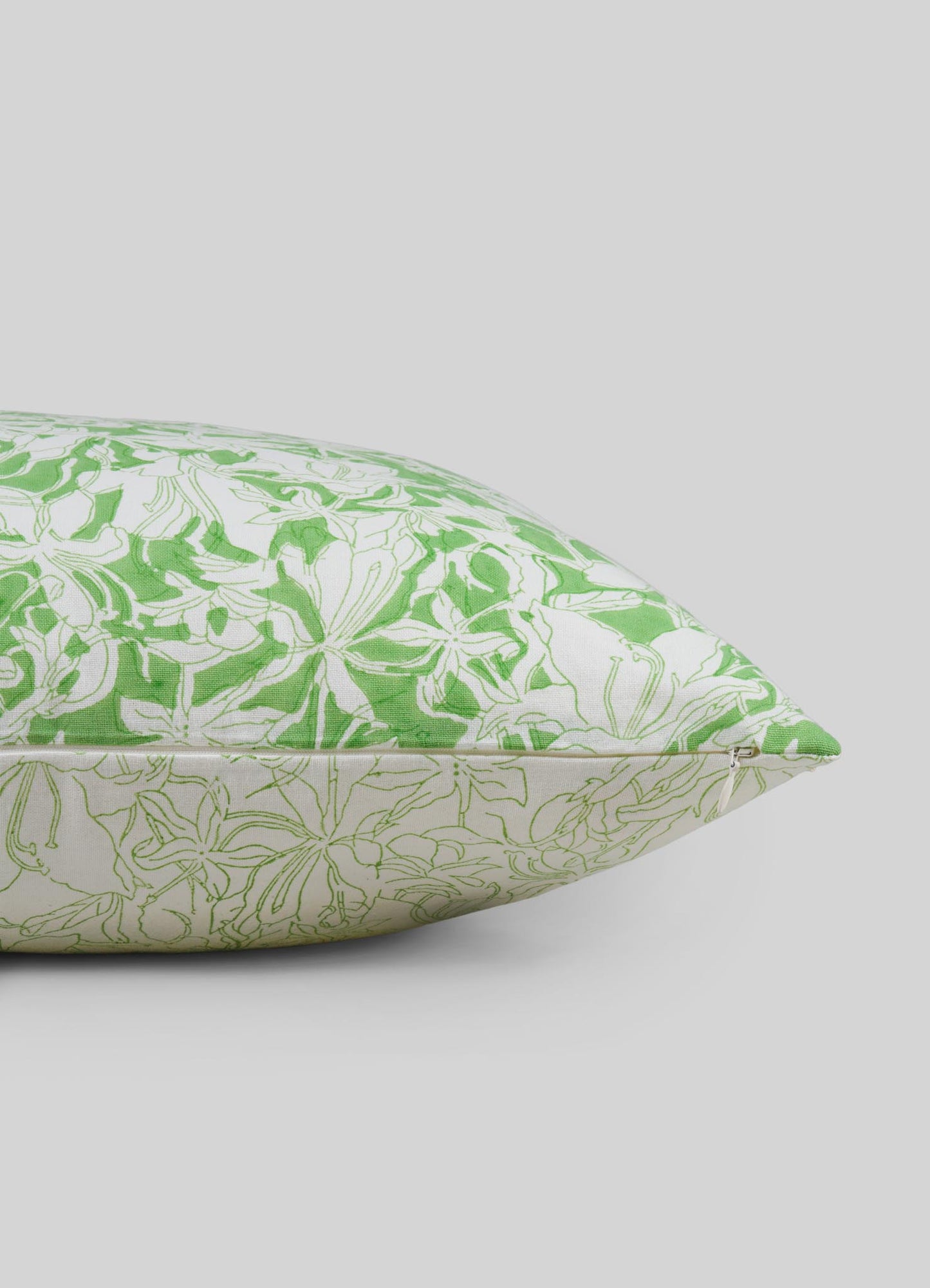 Green and white floral patterned pillow cover on a light gray background viya