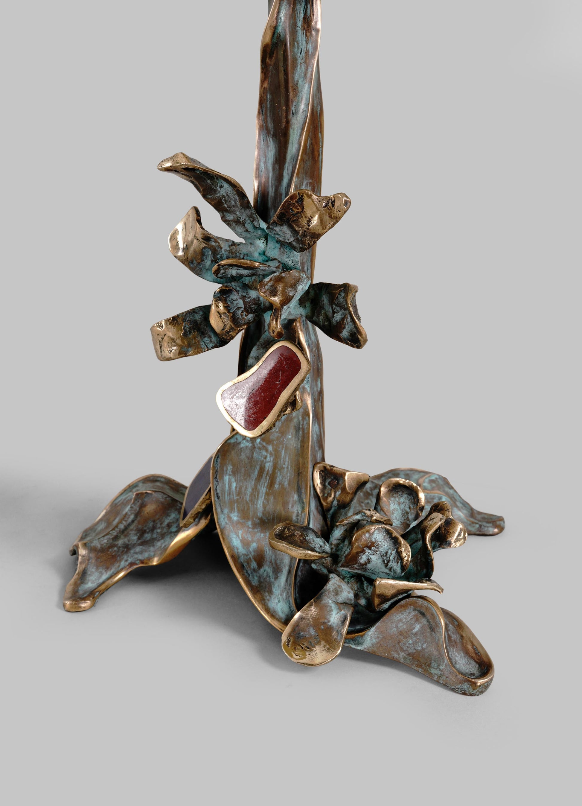 Decorative metal sculpture in bronze finish featuring abstract, organic shapes with a mix of smooth and textured surfaces, set against a plain background.