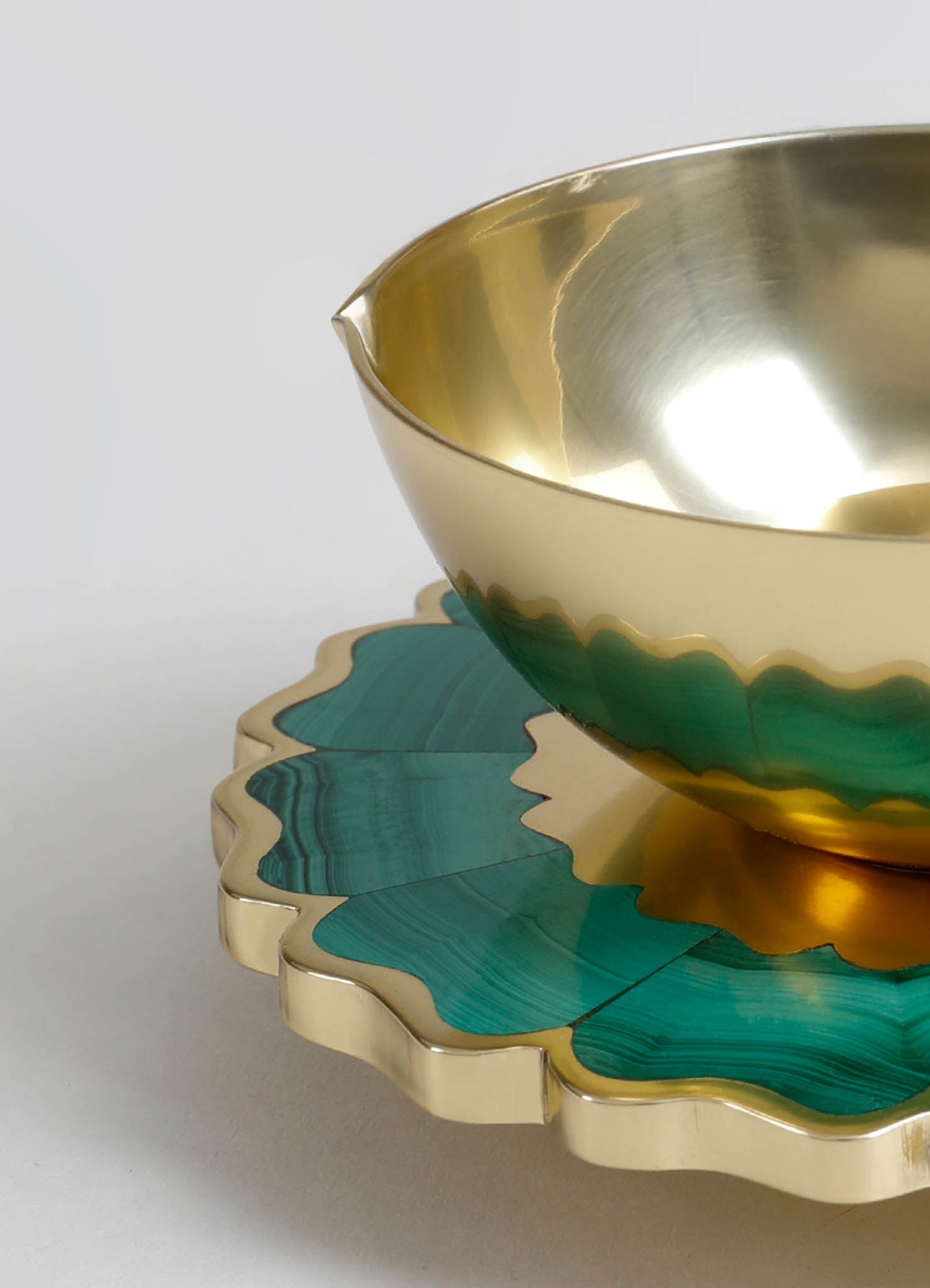 Brass and malachite-patterned decorative bowl with a smooth, polished surface and scalloped edges, paired with a matching malachite tray featuring a wavy border and layered green and gold tones.