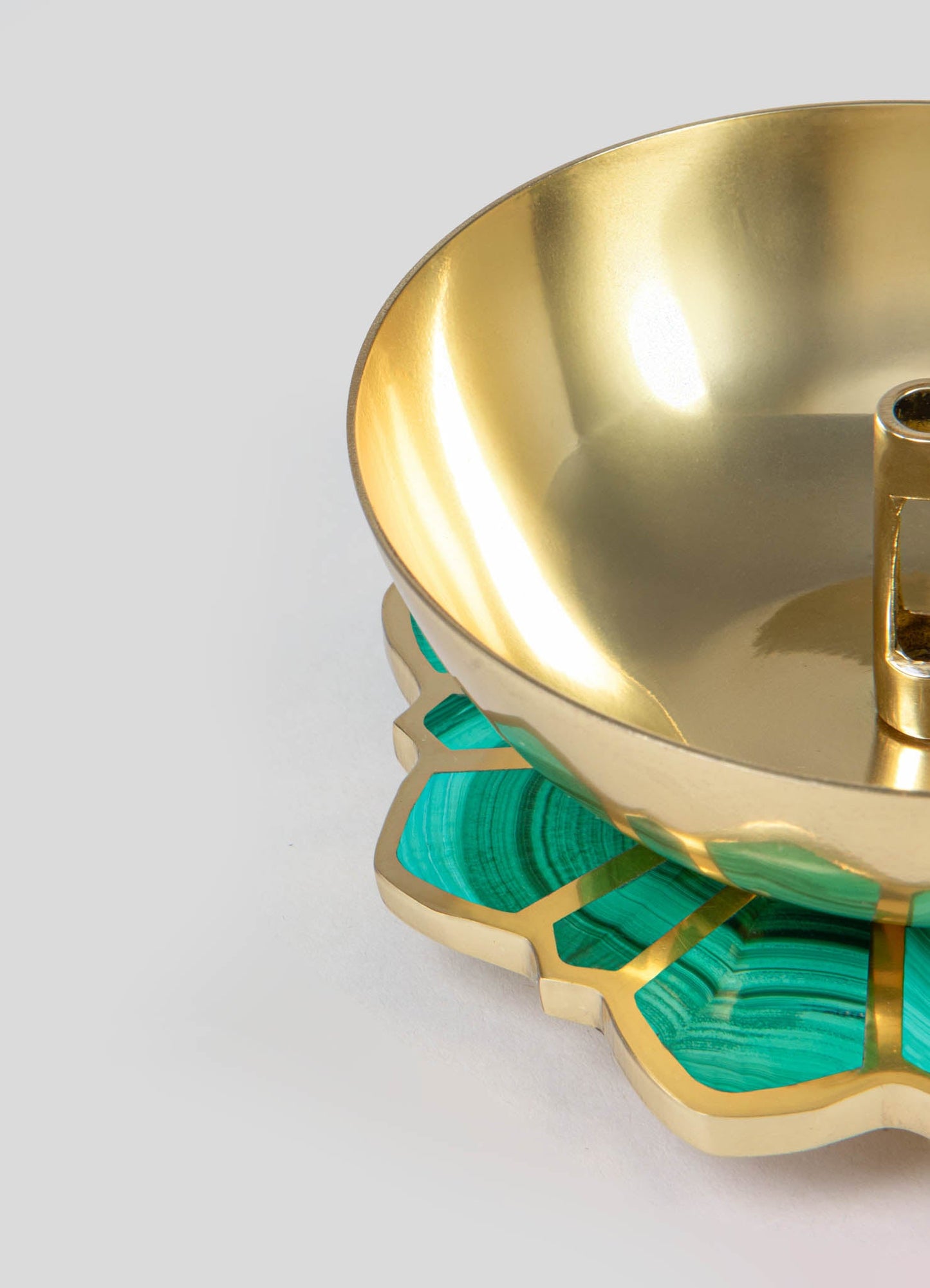 A decorative bowl with a polished gold metal interior and a base featuring a green malachite-like pattern and gold accents, displaying a contemporary style with luxurious material contrast.