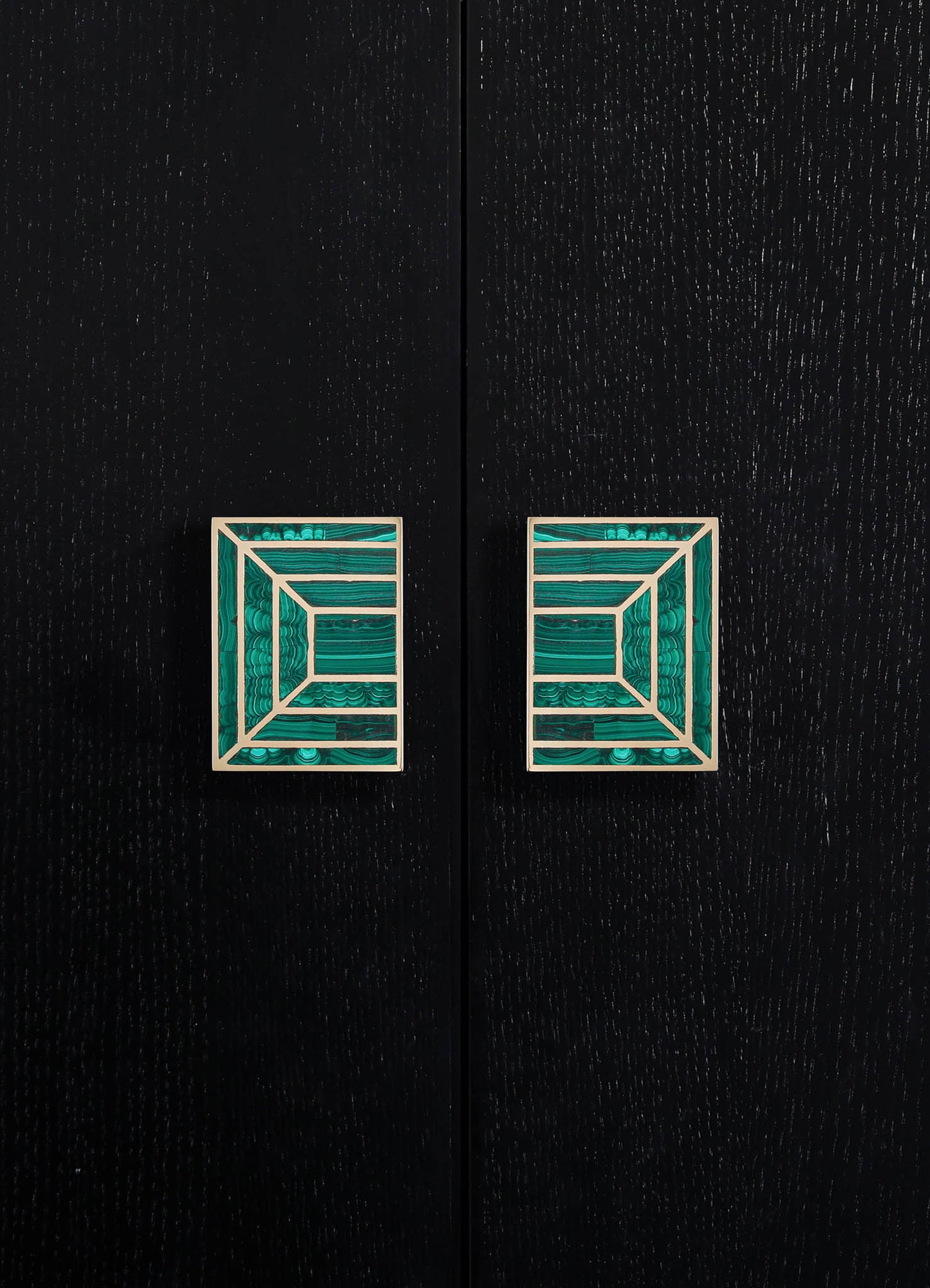 Decorative cabinet handles with geometric motif in turquoise and white, mounted on a black textured wooden surface.
