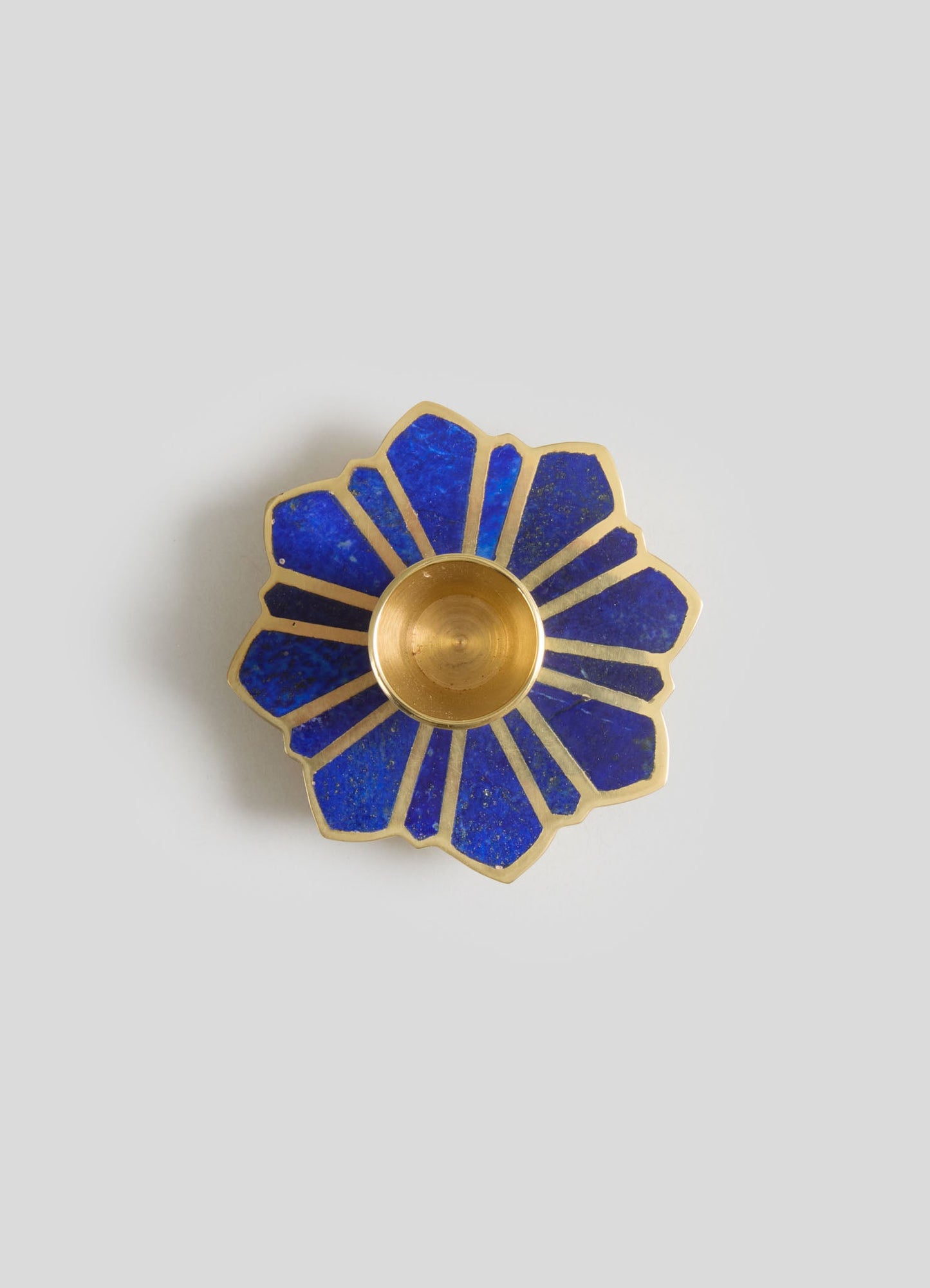 A decorative blue and gold flower-shaped dish with a central gold bowl, featuring geometric blue enamel segments edged in gold.