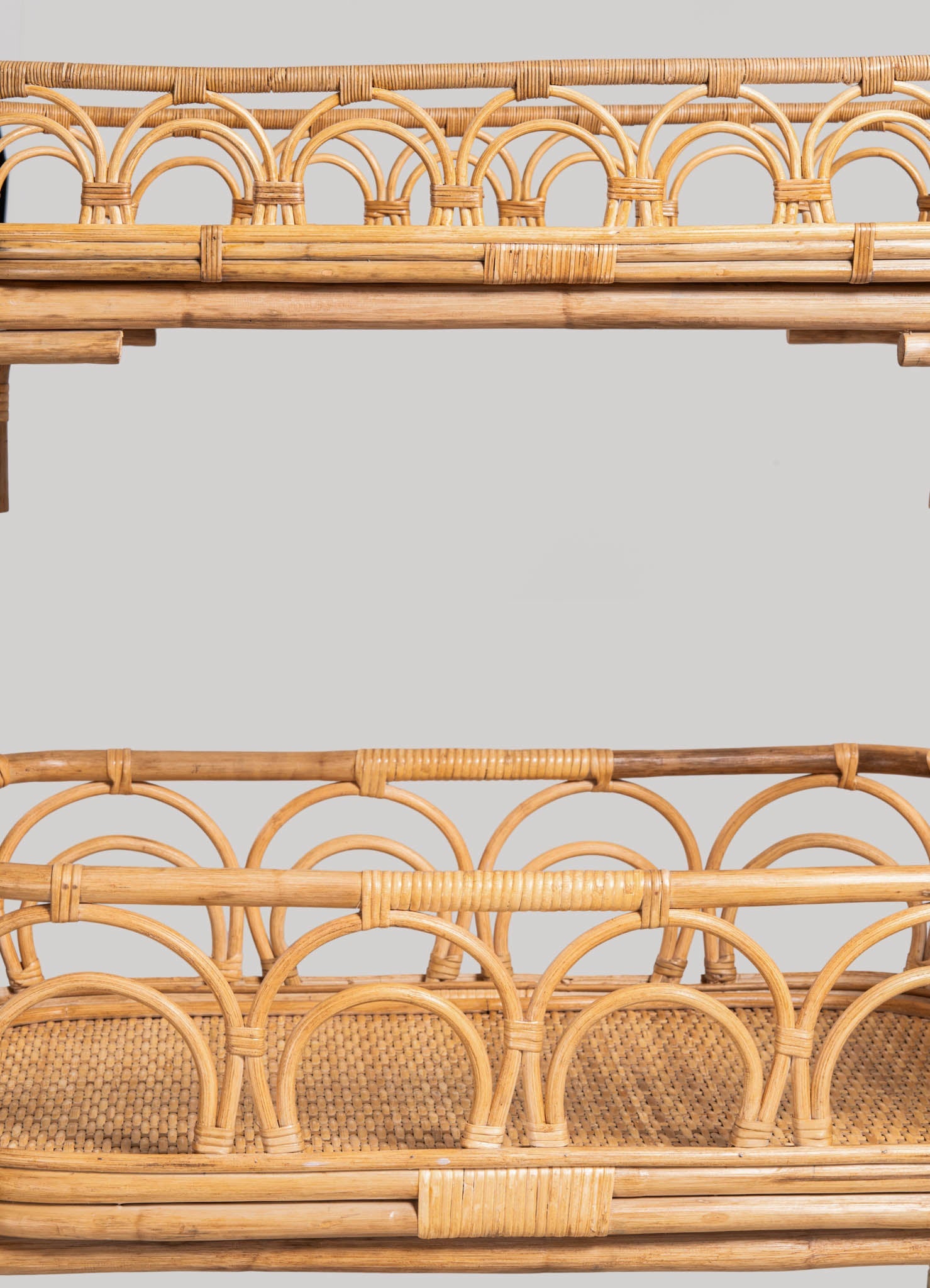 Rattan storage baskets with intricate woven patterns and arched motifs, crafted from natural wicker material, set against a neutral background.