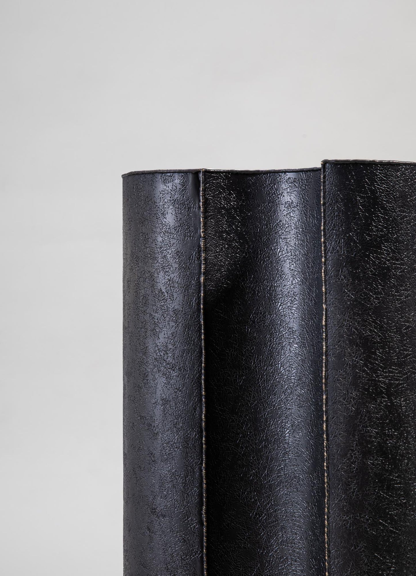 Leather table or furniture covering in black with a textured, crackled finish and visible stitching along the edges.
