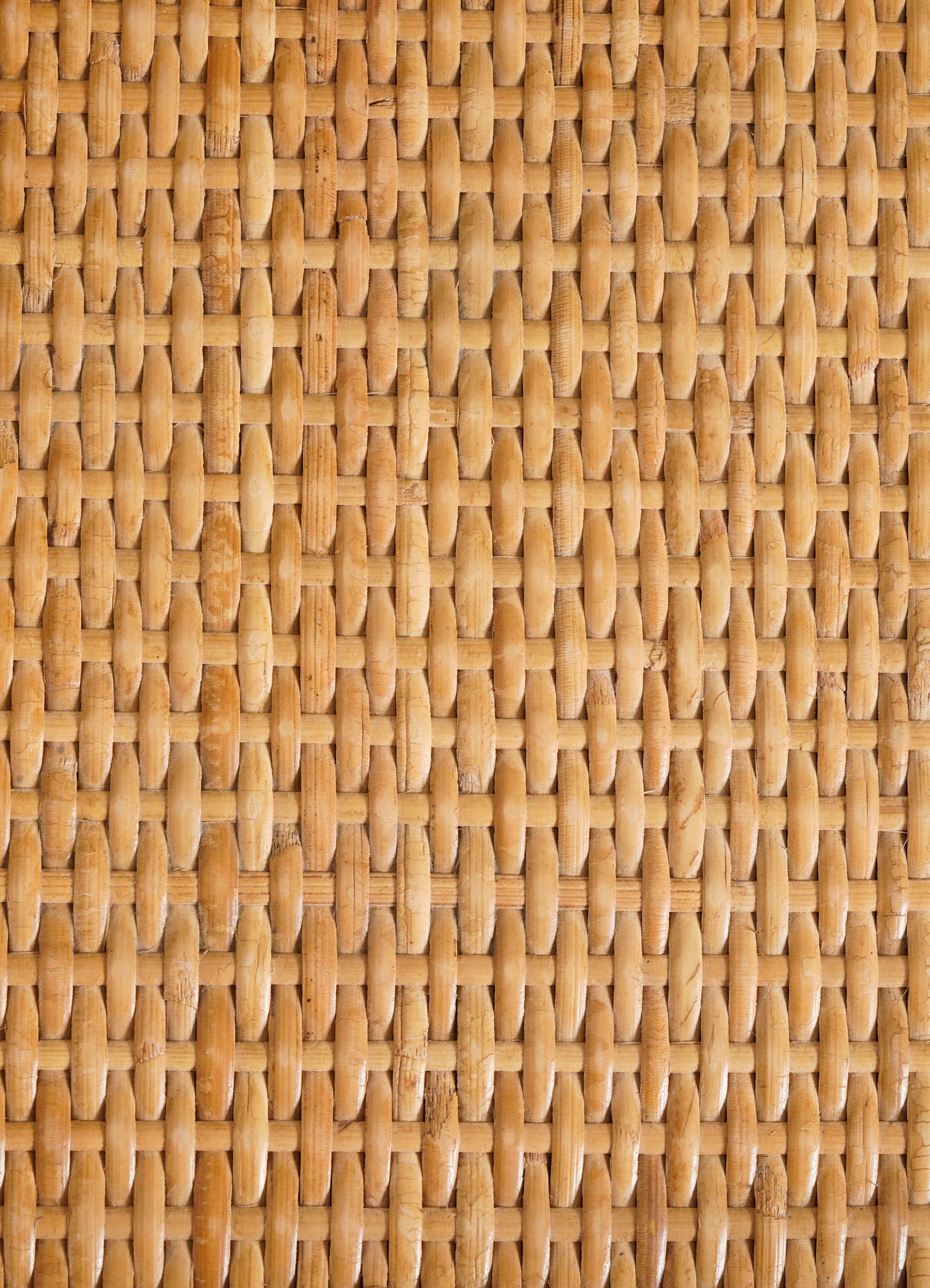 Woven rattan surface in a tight, hexagonal pattern with a warm, natural wood-tone finish.