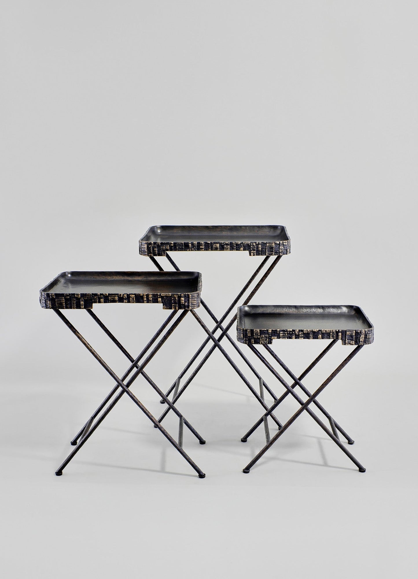 Set of three nesting trays with black lacquered wood surfaces and metal frame supports, featuring a minimalist geometric design.