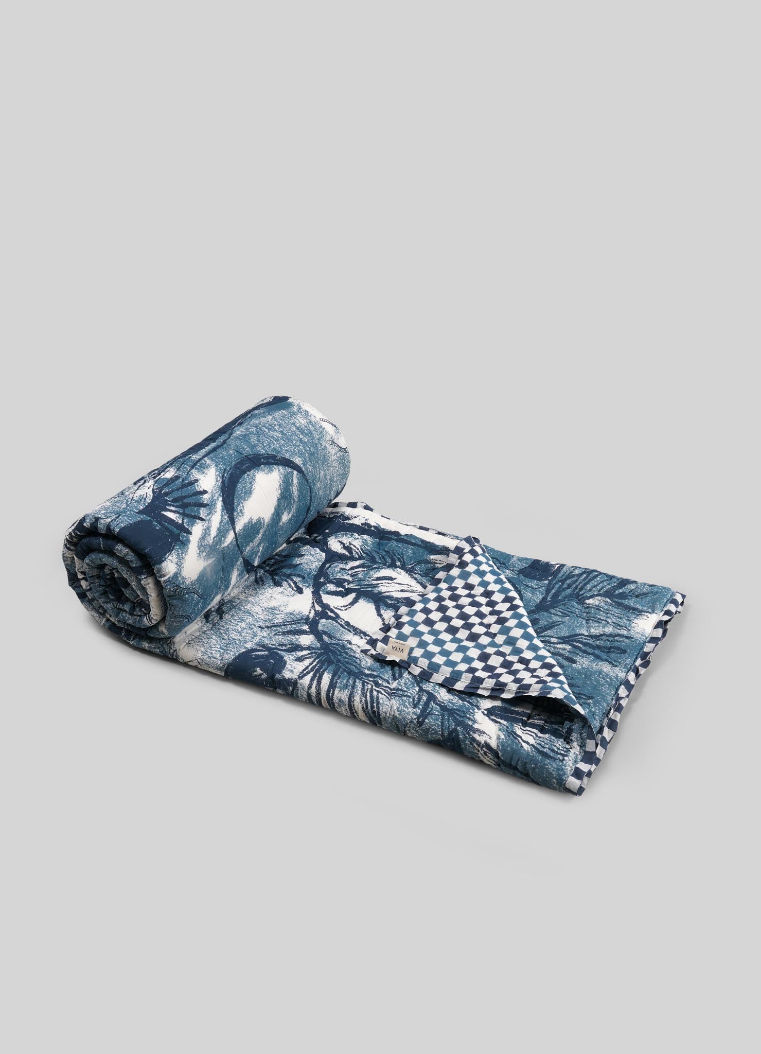 Rolled-up fabric with blue floral and checkered patterns on a gray lbackground viya luxury cotton quilt covers