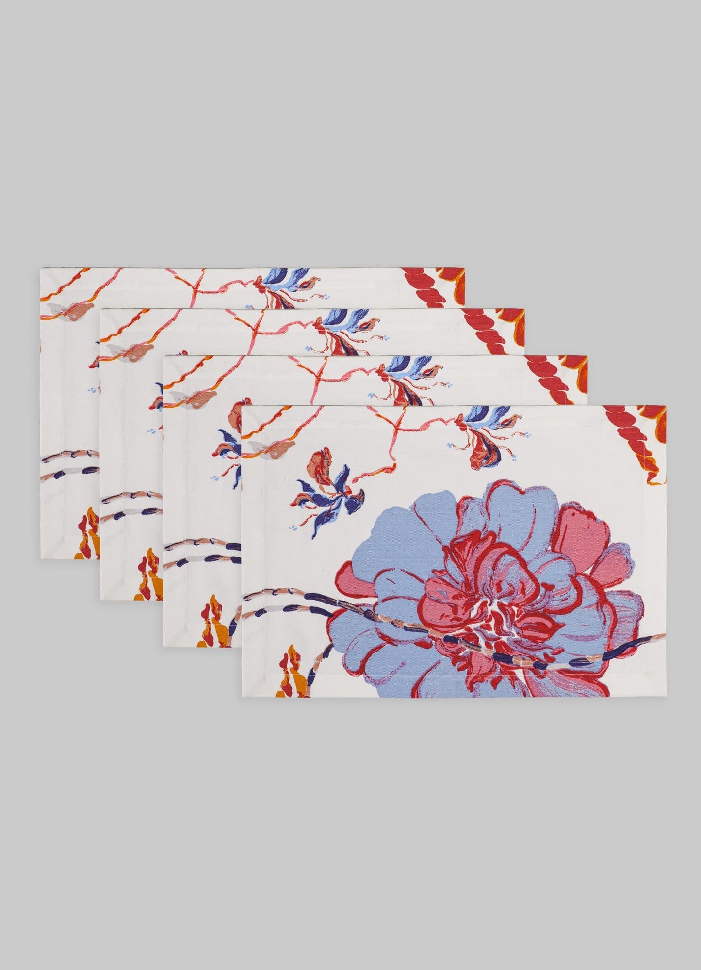 Set of six fabric placemats with a floral pattern in red, blue, and orange tones on a white background, with a decorative border in orange and red.