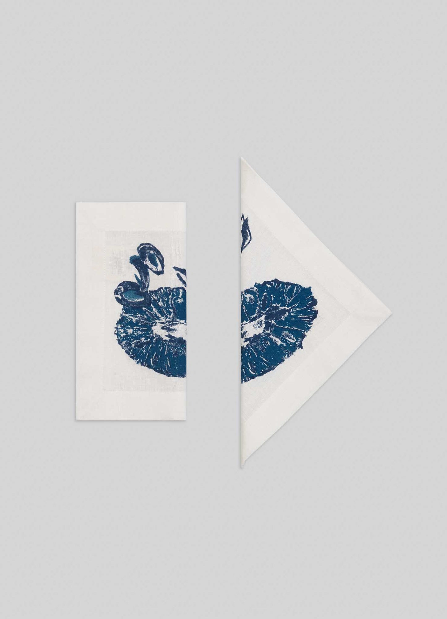 A set of four Orchard Blue Cocktail Napkins by Viya, featuring a blue mushroom print, arranged side by side on a light gray background—perfect for adding Indian fruit orchard-inspired charm to your table.