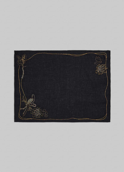 Black fabric square with gold embroidery on a gray background viya luxury placemats