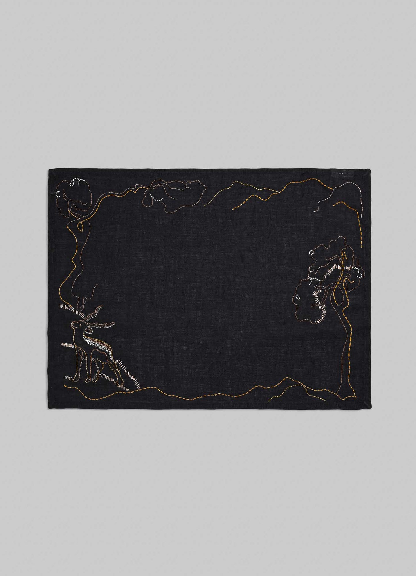 Black fabric with embroidered designs on a gray background viya luxury placemats
