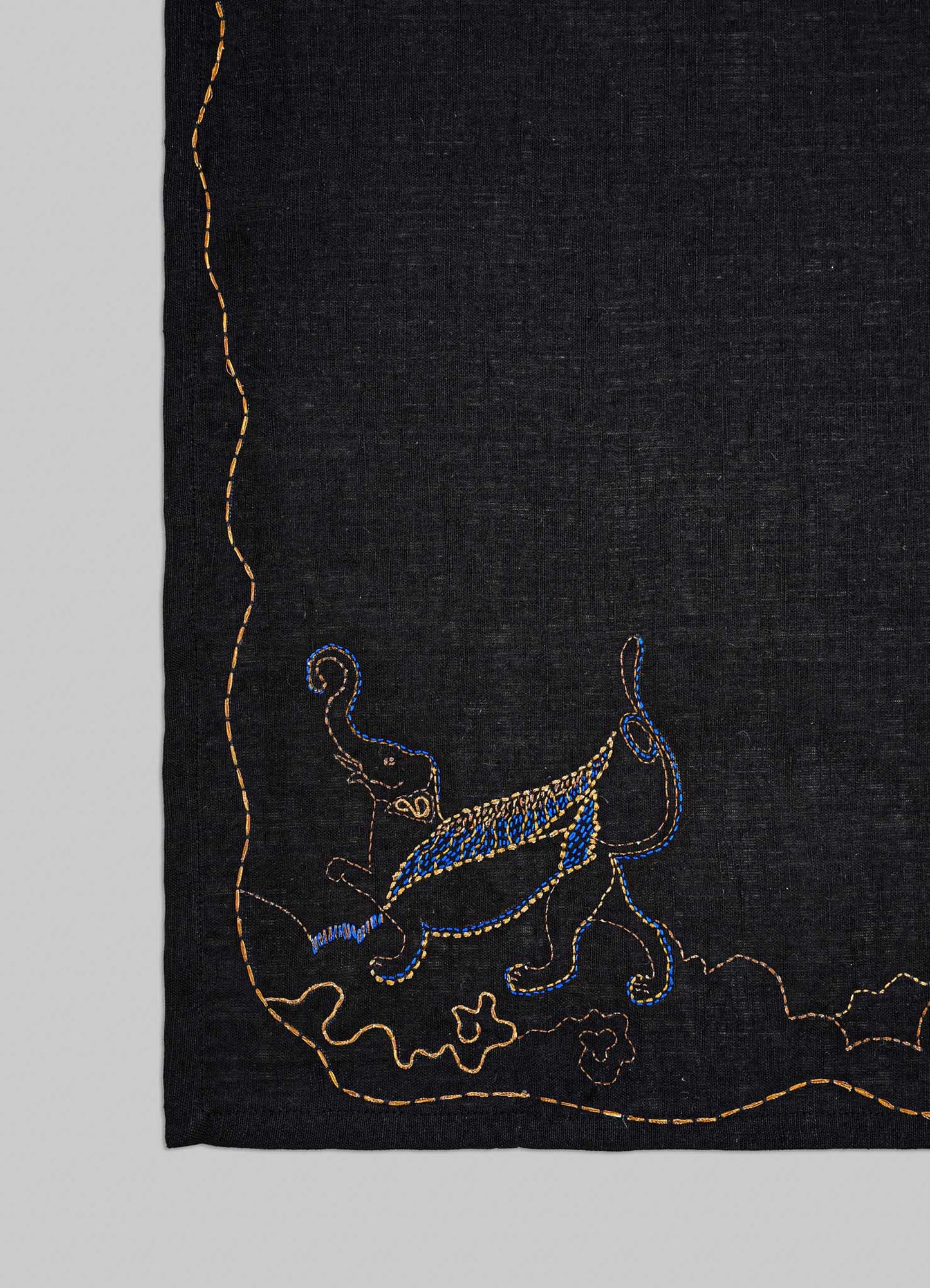 Embroidered design on a black fabric with blue and gold elements viya luxury placemats