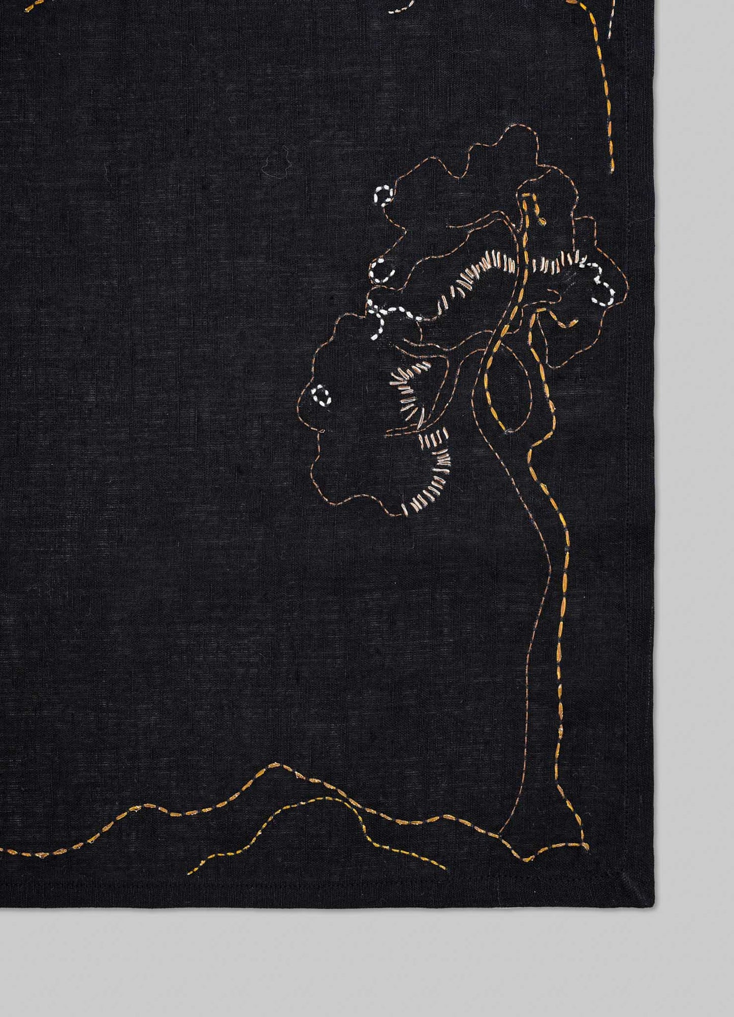 Black fabric with gold embroidery of floral patterns on a gray background viya luxury placemats