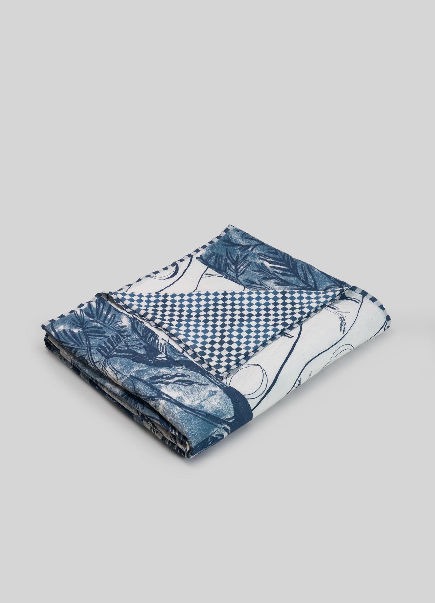 Folded fabric with blue and white patterns on a gray background luxury cotton quilts viya