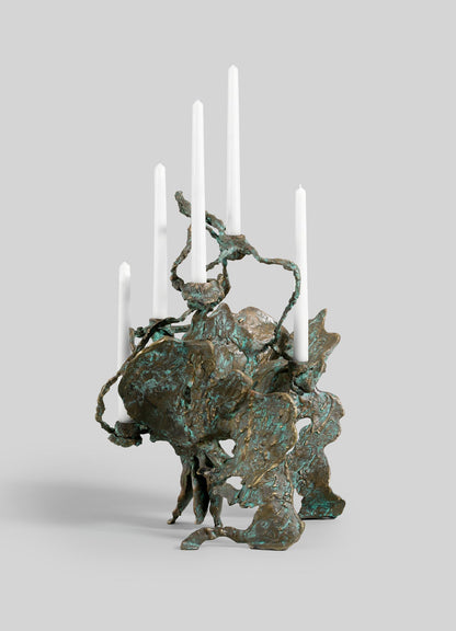 The VIYA Butterfly Candle Stand Large is a sculptural bronze candelabra with an organic, abstract form and a textured, oxidized greenish patina. It holds six white taper candles at varying heights.