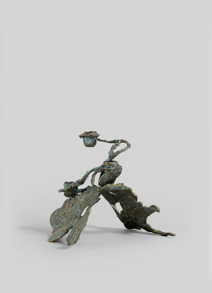 The VIYA Butterfly Candle Stand Small features a bronze, textured organic form with abstract oak leaves and acorns, displayed against a plain light gray background.