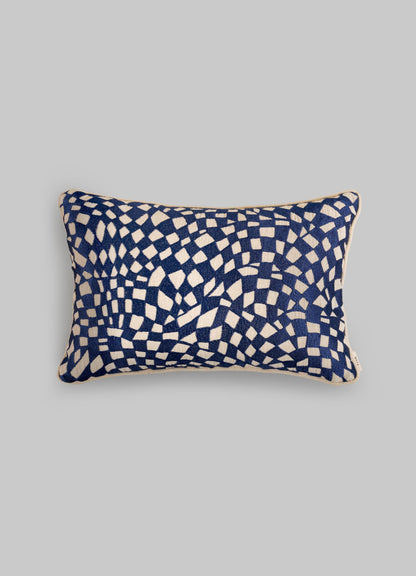 The Viya Dreamscape Blue Embroidered Checks Cushion Cover 12"x18" features navy and white geometric motifs with scattered, curved squares on a plain gray base.