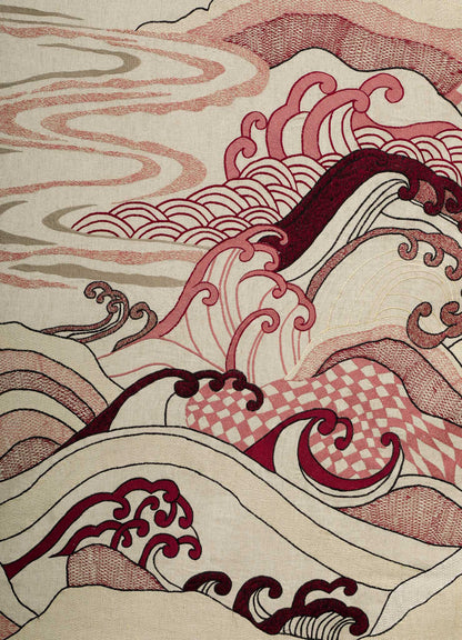 The Dreamscape Ecru Embroidered Bedcover by Viya features abstract waves and clouds in red, pink, and cream, with intricate patterns and flowing lines inspired by traditional Japanese art.