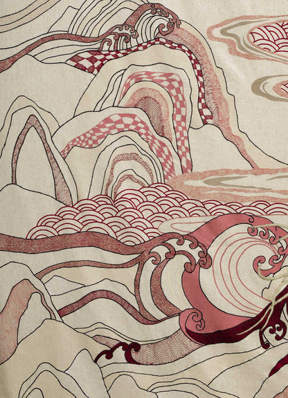 The Viya Dreamscape Ecru Embroidered Bedcover features an abstract landscape of waves, swirling lines, and mountain shapes in red, pink, and beige, inspired by embroidered textiles with repeating patterns and flowing forms.