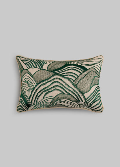 The Viya Dreamscape Green Embroidered Mounds Cushion Cover (12"x18") features abstract, wavy green and beige lines inspired by textile motifs, set against a plain gray background.