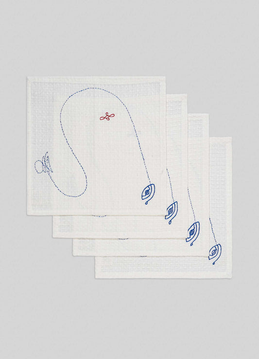 A set of four ecru hand-embroidered face towels by Viya, inspired by the Evil Eye motif, are stacked on a light gray background. Blue embroidery and unique designs decorate each towel in this protective Nazar-themed set.
