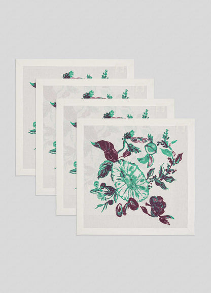The Viya Jackfruit Green Napkins, set of 4, feature a lush botanical pattern with green and purple flowers and leaves on light grey fabric, inspired by Indian fruit orchards.