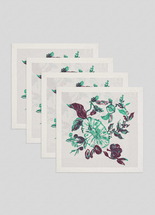 The Viya Jackfruit Green Napkins, set of 4, feature a lush botanical pattern with green and purple flowers and leaves on light grey fabric, inspired by Indian fruit orchards.