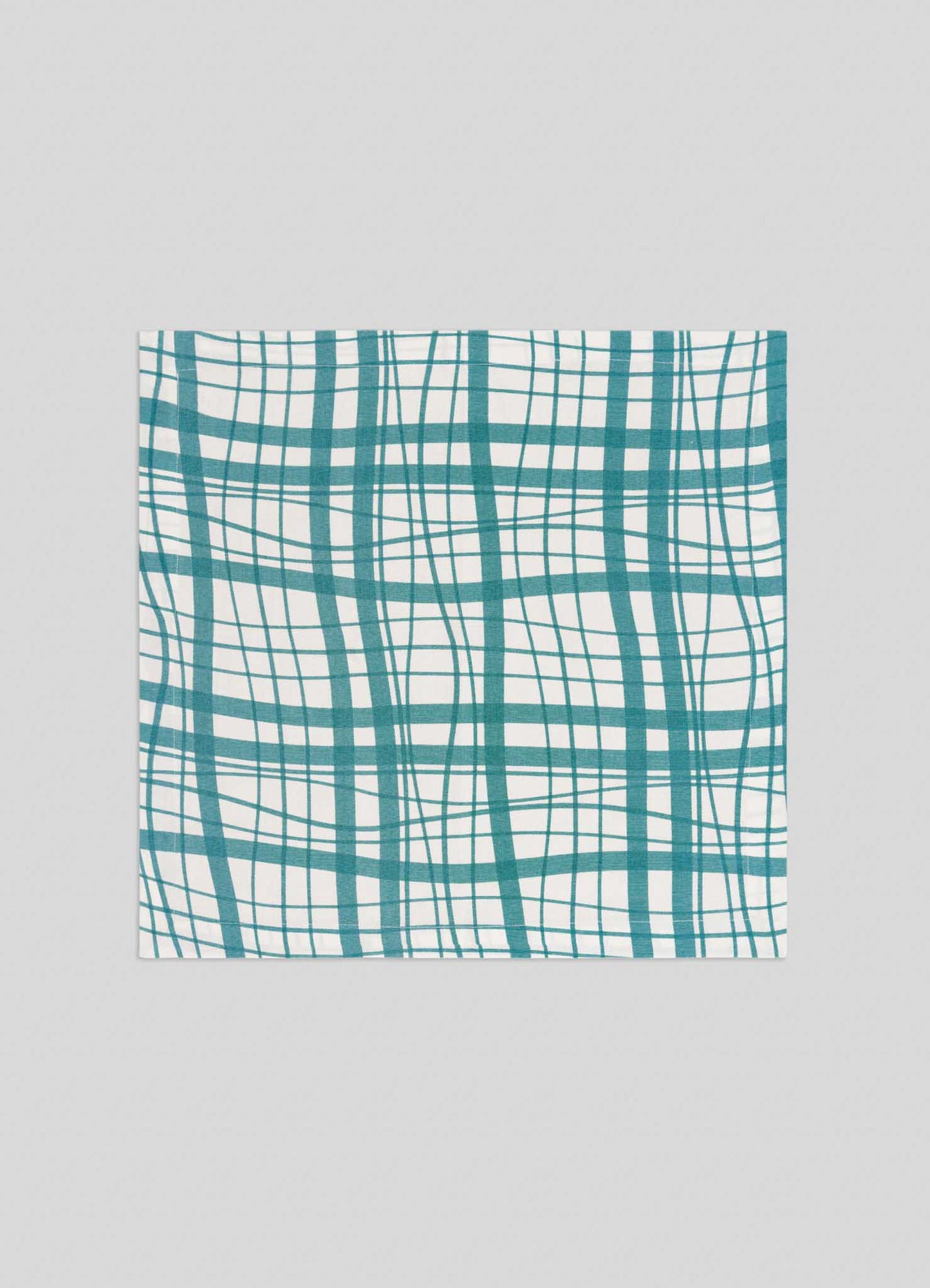 The Viya Madras Check Aqua Napkins – Set of 4 features teal and green madras checks on white fabric, shown flat on a light grey surface—perfect for bringing classic charm to your modern collection.