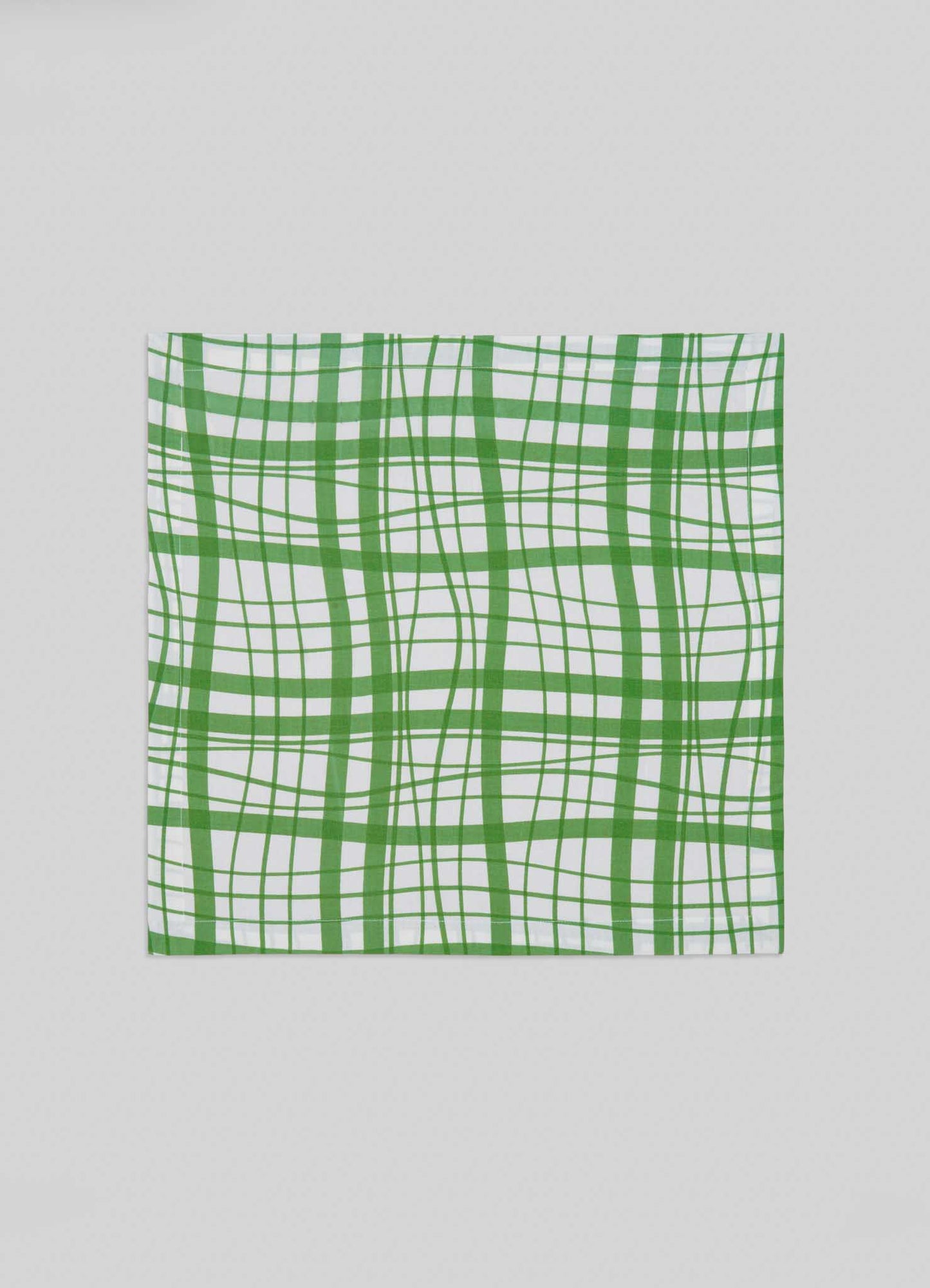 The Viya Madras Check Green Napkins - Set of 4 feature a square white fabric with a modern wavy green plaid inspired by Indian Madras checks and intersecting lines in varying thicknesses.