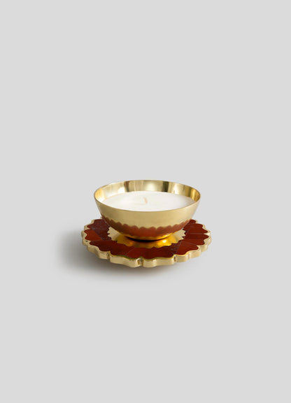 The Viya Mystical Marigold Red Scented Candle Diya Small (Set of 2) features gold, bowl-shaped candles with scalloped edges, placed on red and gold flower coasters, beautifully displayed against a light gray background.