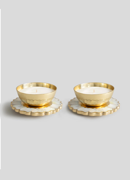 The Viya Mystical Marigold White Scented Candle Diya Small Set of 2 features gold-toned tealights in round holders on white and gold floral bases, showcasing modern heirloom charm inspired by ancient metalwork.