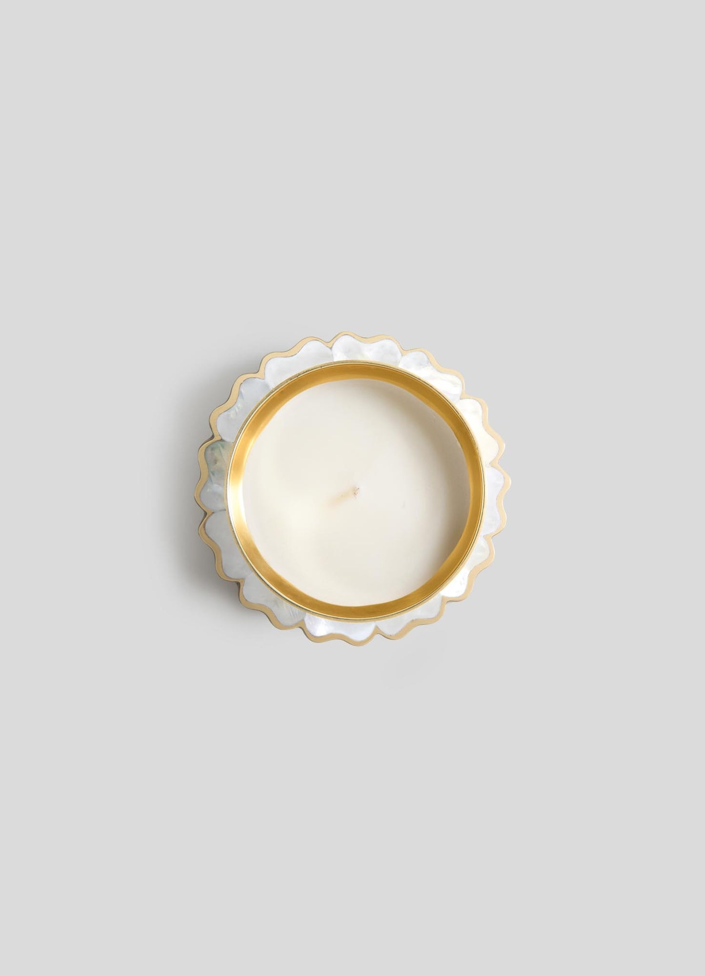 A top-down view of Viya's Mystical Marigold White Scented Candle Diya Small (Set of 2), in a round white holder with gold scalloped trim, crafted using ancient metalworking techniques, displayed on a light gray background.