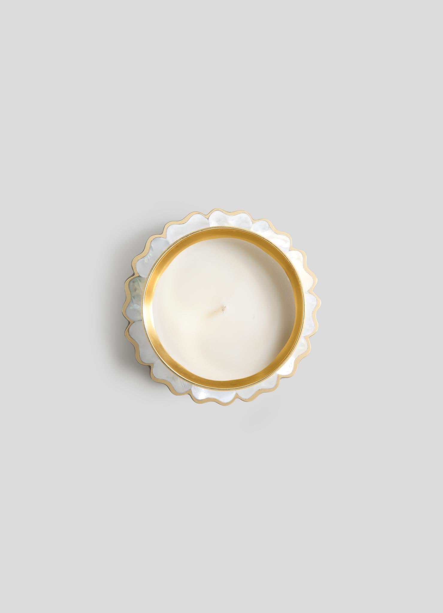 A top-down view of Viya's Mystical Marigold White Scented Candle Diya Small (Set of 2), in a round white holder with gold scalloped trim, crafted using ancient metalworking techniques, displayed on a light gray background.