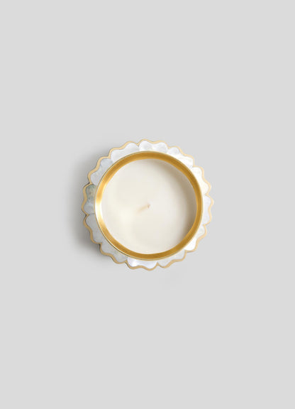 A top-down view of Viya's Mystical Marigold White Scented Candle Diya Small (Set of 2), in a round white holder with gold scalloped trim, crafted using ancient metalworking techniques, displayed on a light gray background.