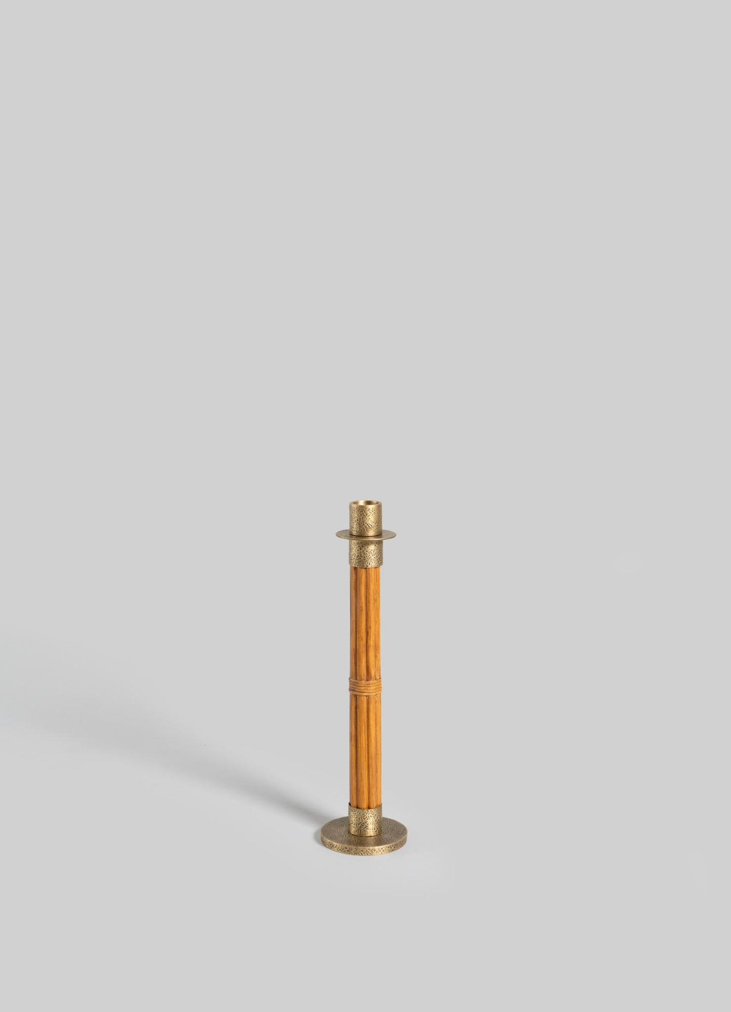 The VIYA Namsai Candle Holder Medium, featuring elegant brass and wood design, stands upright on a light gray background and casts a faint shadow to the left.