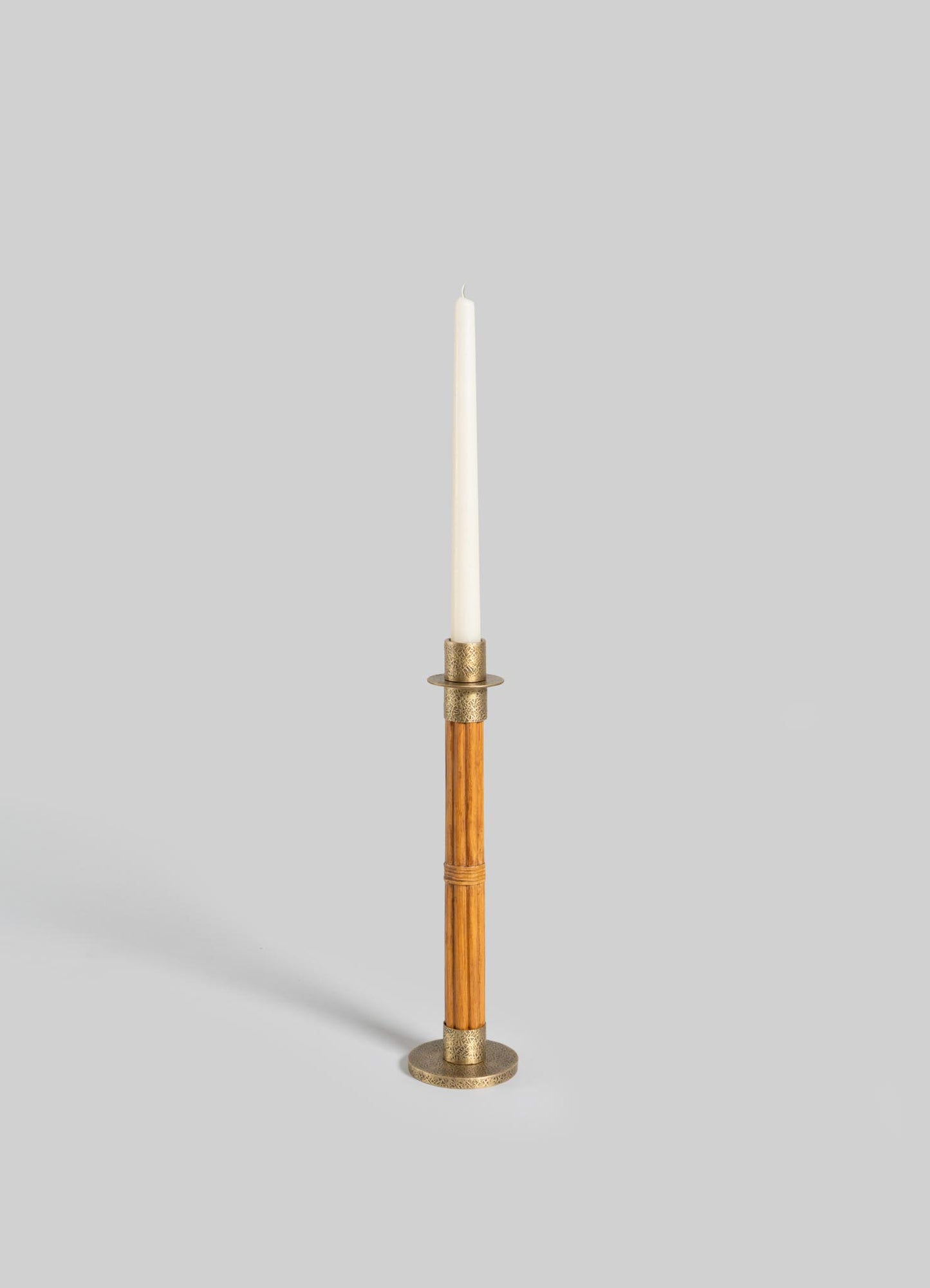 The VIYA Namsai Candle Holder Medium, a tall cylindrical wooden holder with elegant brass accents, holds a white taper candle upright against a plain light gray background.