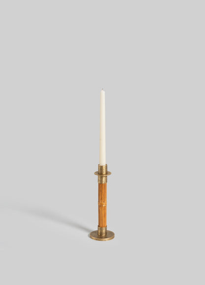 The VIYA Namsai Candle Holder Small features brass and wood with a textured round base, brass trimmings, and a ring detail. Shown holding a white taper candle against a plain light gray background.