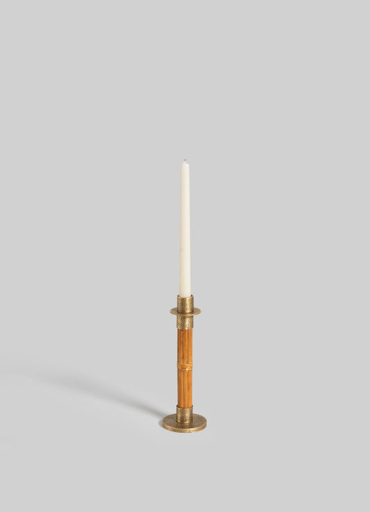 The VIYA Namsai Candle Holder Small features brass and wood with a textured round base, brass trimmings, and a ring detail. Shown holding a white taper candle against a plain light gray background.