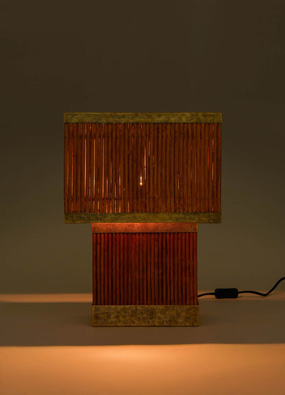 The VIYA Namsai Table Lamp Large features a rectangular shade and vertical wooden slat base with subtle brass accents. It emits warm, soft light and sits on a flat surface with a visible power cord.