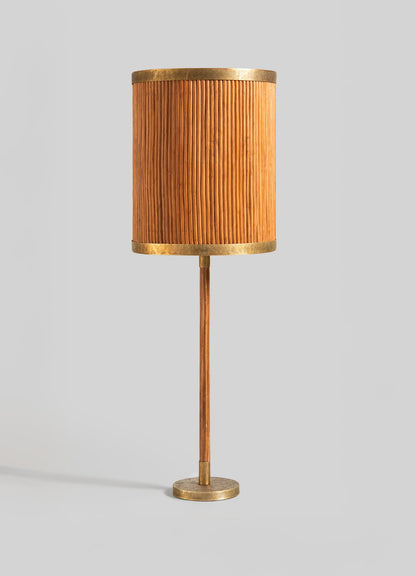 The Namsai Table Lamp Tall by VIYA features a cylindrical, pleated orange-brown shade with gold brass accents on the top, bottom, base, and stem, showcased against a plain light gray background.