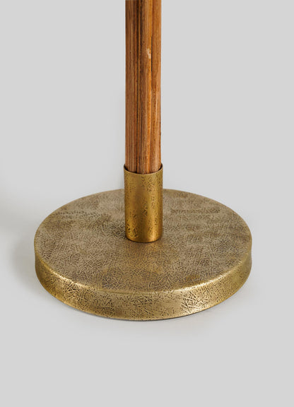 Close-up of the Namsai Table Lamp Tall by VIYA, featuring a round, textured brass base with elegant trimmings and a wooden pole set in a brass holder, all against a plain light gray background.
