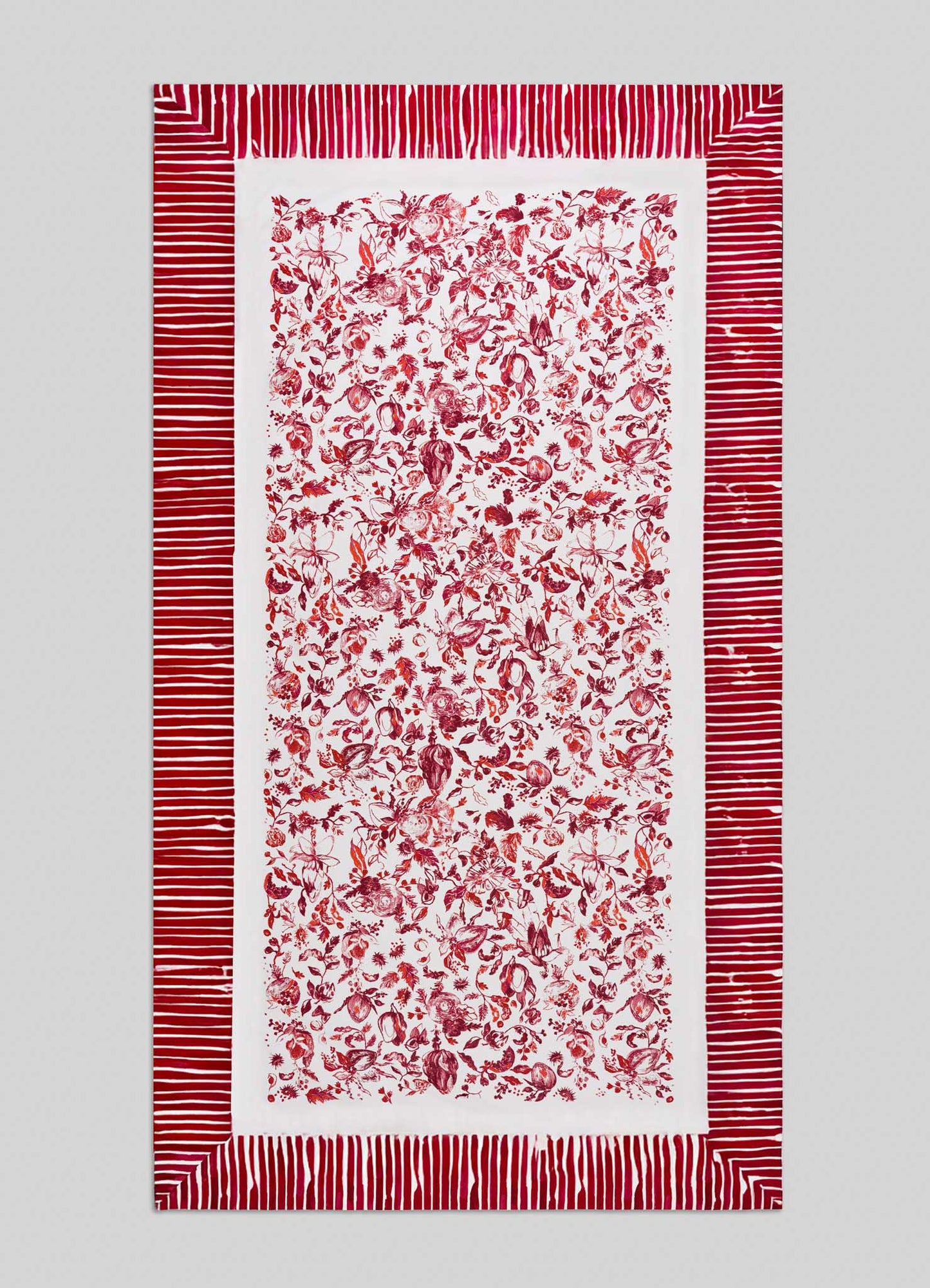 The Viya Orchard Red Table Cloth Large features a dense central pattern of red floral and botanical motifs inspired by Indian pomegranate on white, accented with wide red and white horizontal border stripes.