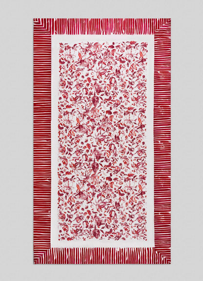 The Viya Orchard Red Table Cloth Large features a dense central pattern of red floral and botanical motifs inspired by Indian pomegranate on white, accented with wide red and white horizontal border stripes.