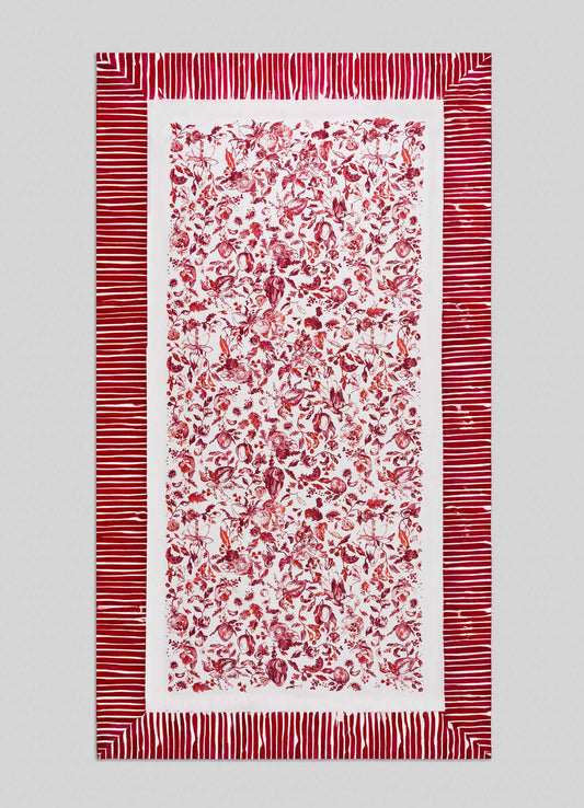 The Viya Orchard Red Table Cloth Large features a dense central pattern of red floral and botanical motifs inspired by Indian pomegranate on white, accented with wide red and white horizontal border stripes.