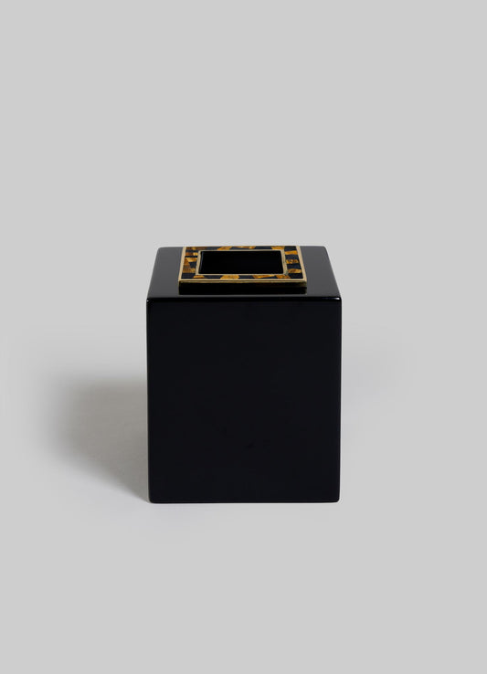 The VIYA Plaza Cube Tissue Box features a black, glossy, cube-shaped design with a gold-bordered slot on top, inspired by the Art Deco elegance of Bombay's historic cinema halls, set against a plain light gray background.