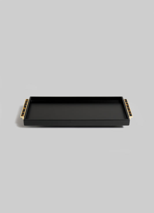 The VIYA Plaza Vanity Tray, rectangular and black with raised edges and gold-tone handles, channels Art Deco elegance inspired by classic Bombay cinema halls. It's shown on a simple light gray background.