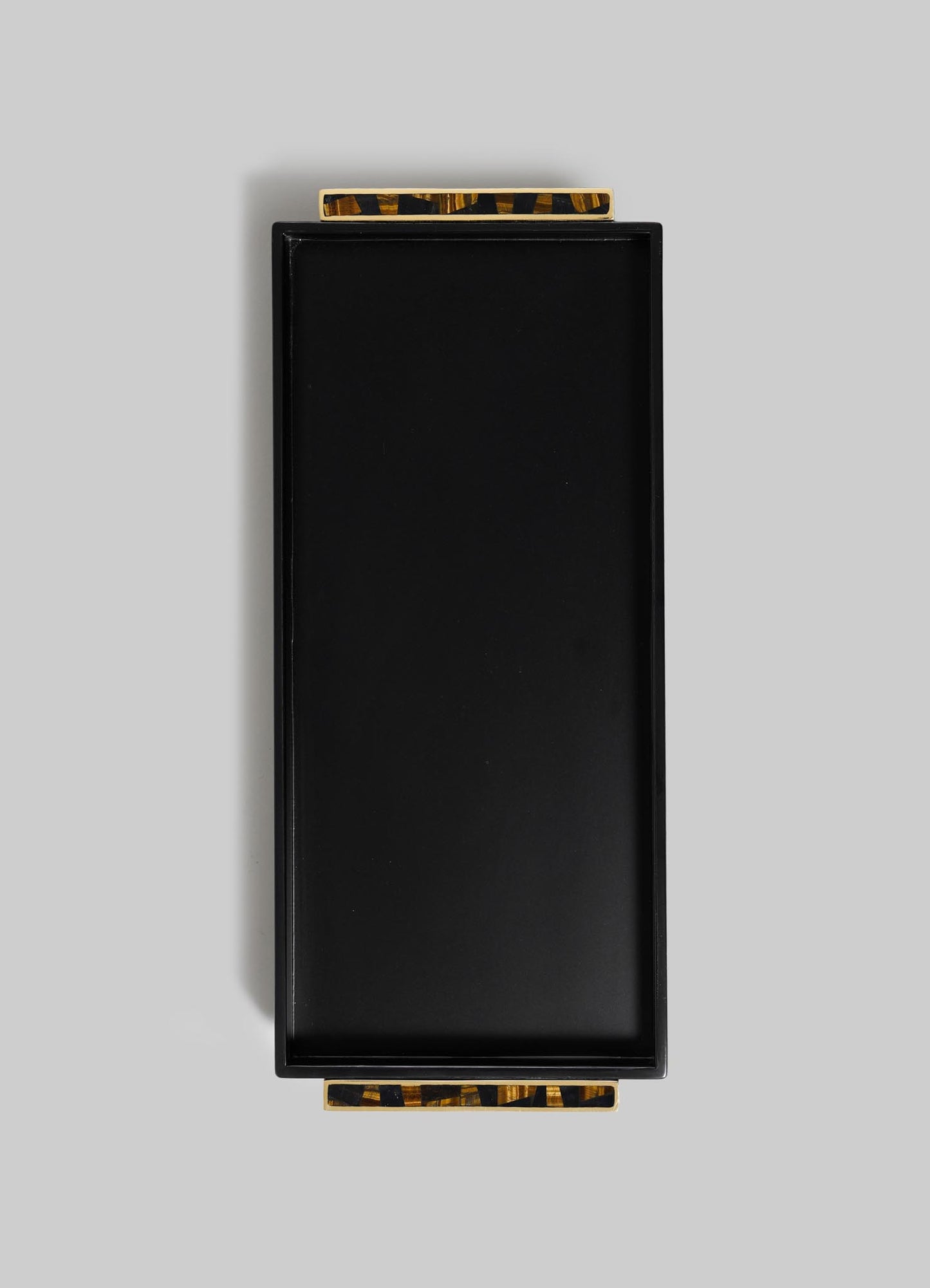 The Plaza Vanity Tray by VIYA, a rectangular black tray with two tortoiseshell-patterned handles and Art Deco flair, is displayed on a light grey background.
